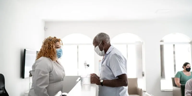 Unit Clerk and patient speaking over counter - What is a typical Unit Clerk/MOA salary?